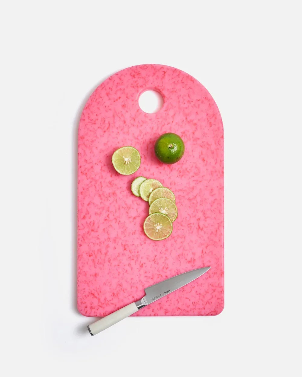 Pink marble-effect cutting board with sliced lime, whole lime, and Mako knife by Marion Grasby