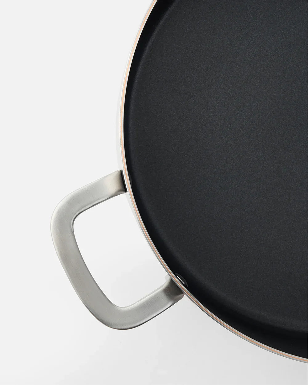 Close-up of a black nonstick frying pan with stainless steel handle by Marion Grasby's Mako