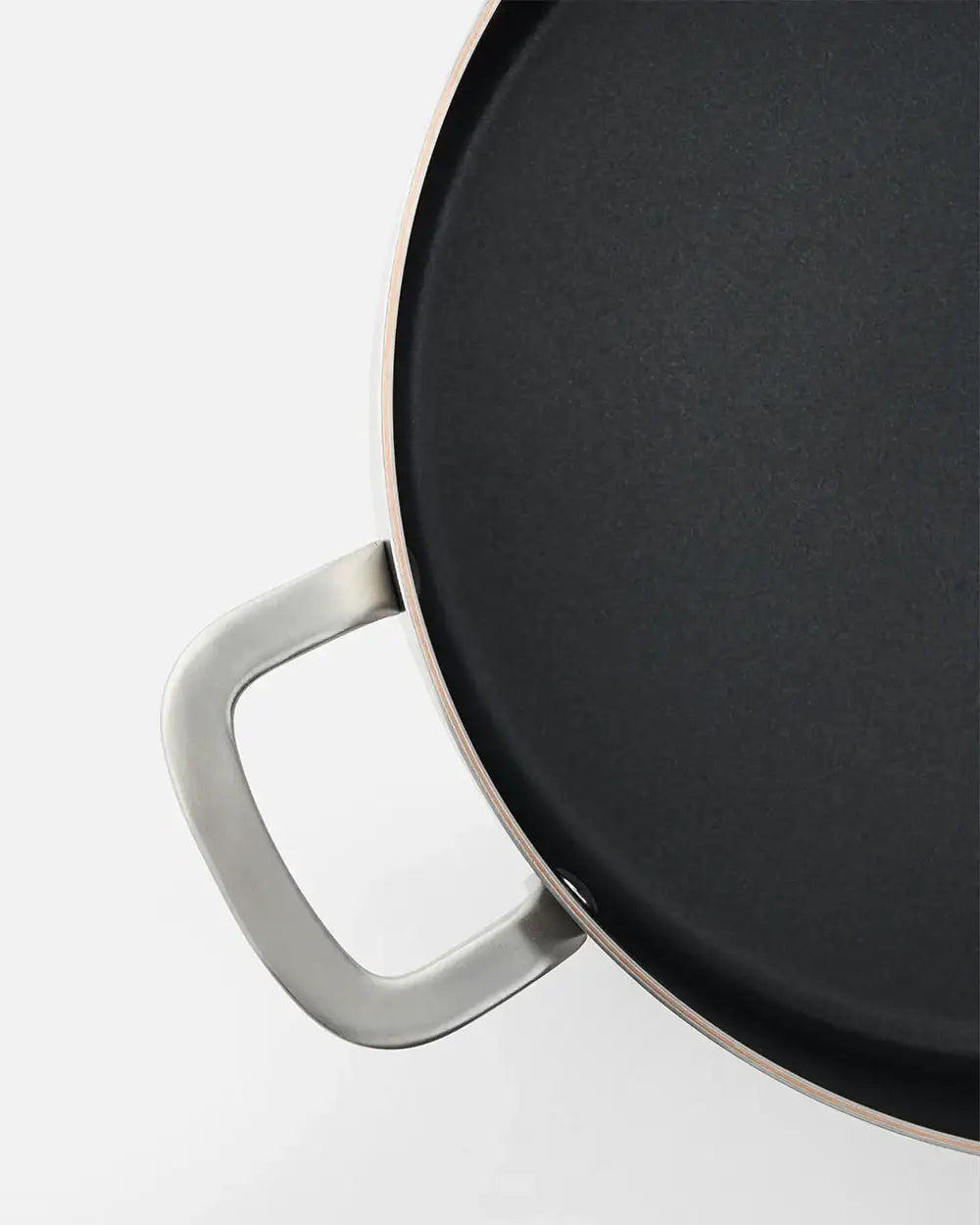 Close-up of a black nonstick frying pan with stainless steel handle by Marion Grasby's Mako