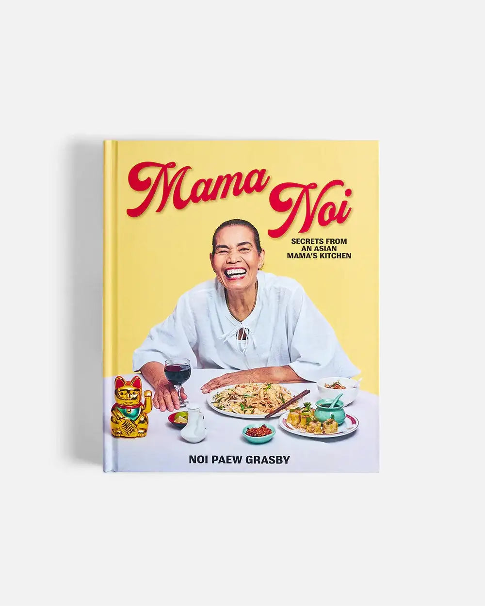 Mama Noi cookbook cover with smiling Asian woman, Asian dishes, and lucky cat figurine