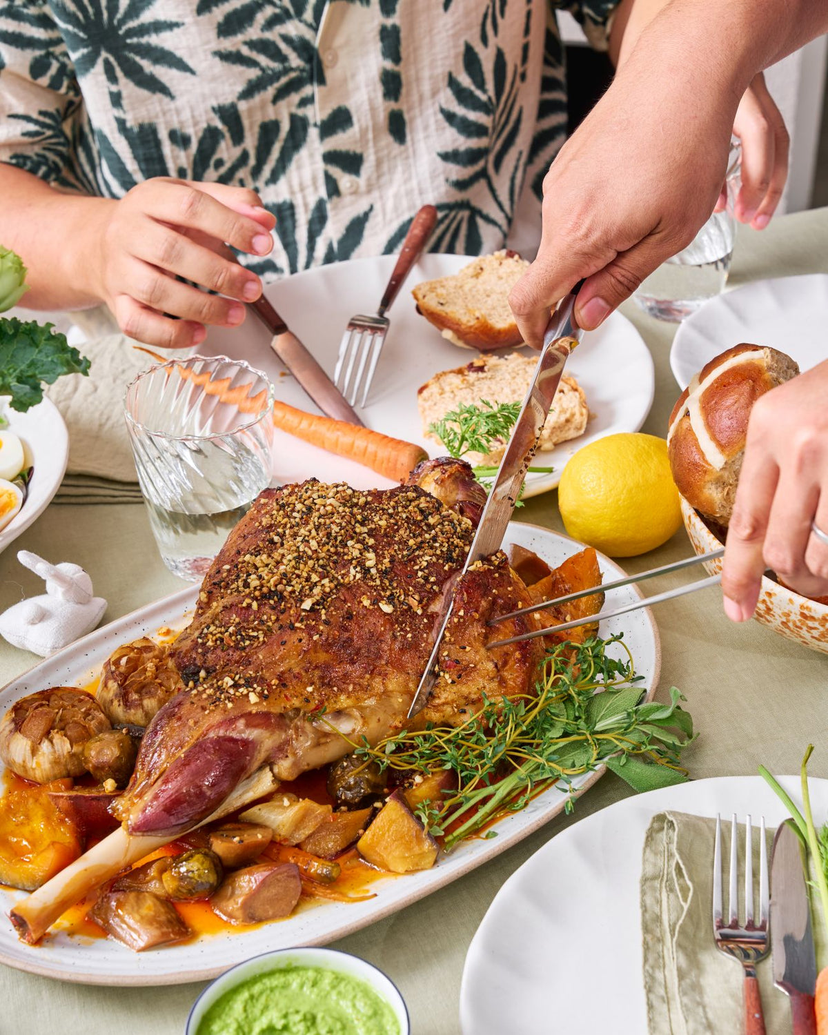 Slow-Roasted Leg of Lamb with Herb Yoghurt Marinade Recipe CookDineHost Serving or cutting lamb on table for guests