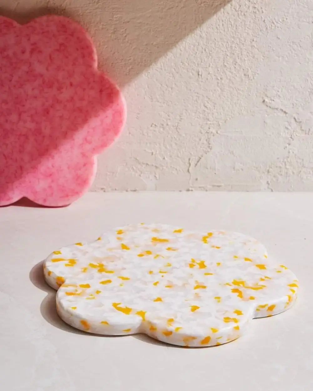 Flower-shaped chopping boards in white with yellow speckles and pink marbled, eco-friendly kitchenware by Marion Grasby