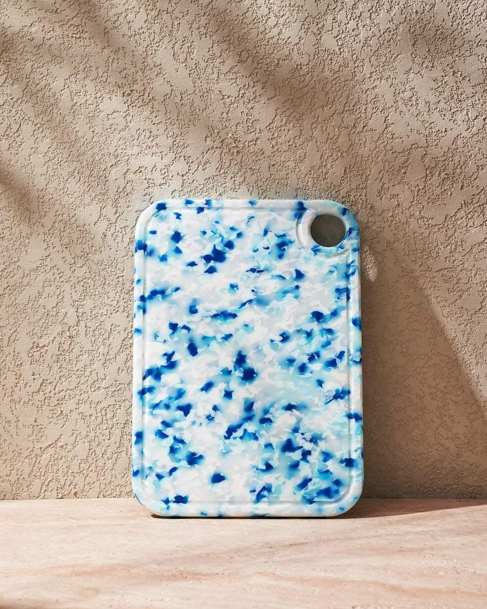 Rectangular blue and white recycled chopping board with rounded edges and a hanging hole