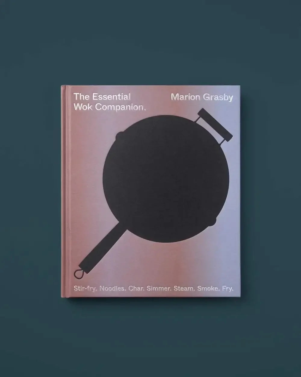 The Essential Wok Companion cookbook with a black wok illustration on a pink and blue cover.