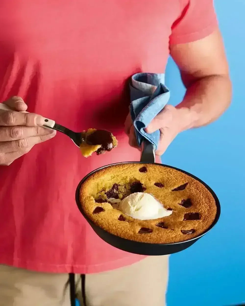 Chocolate chip skillet cookie with vanilla ice cream in a black steel frying pan