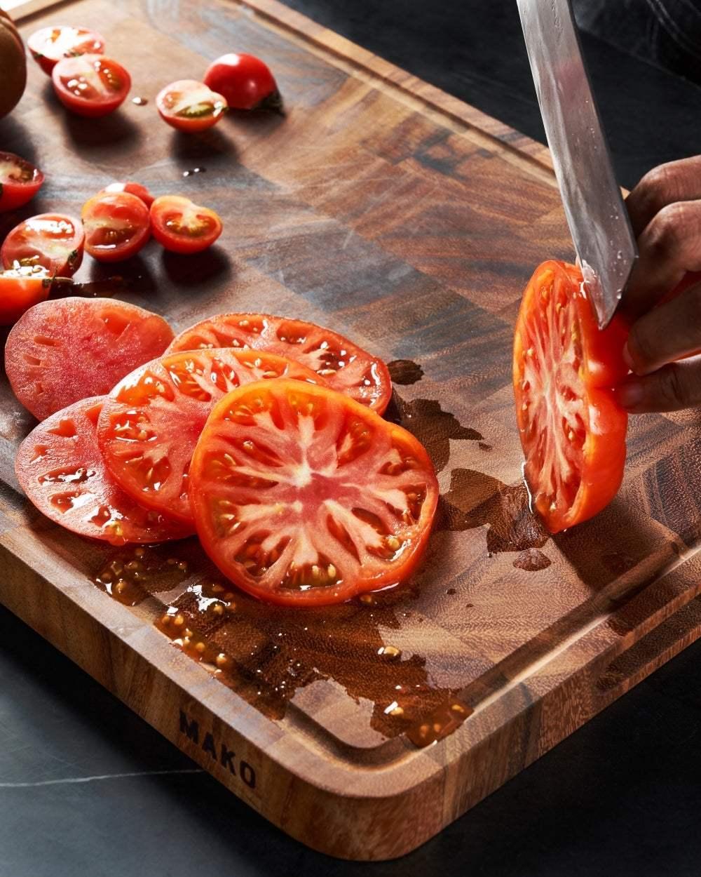 MAKO Master 18 All-Purpose Chopping Board CookDineHost cutting tomatoes with juice running