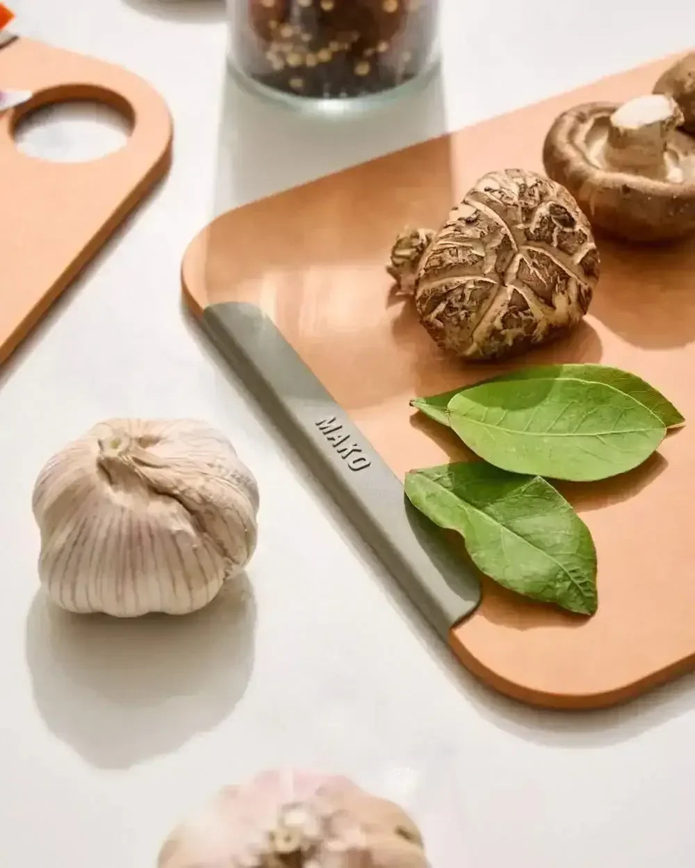 Wood fibre non-slip chopping board with mushrooms, garlic, and green leaves