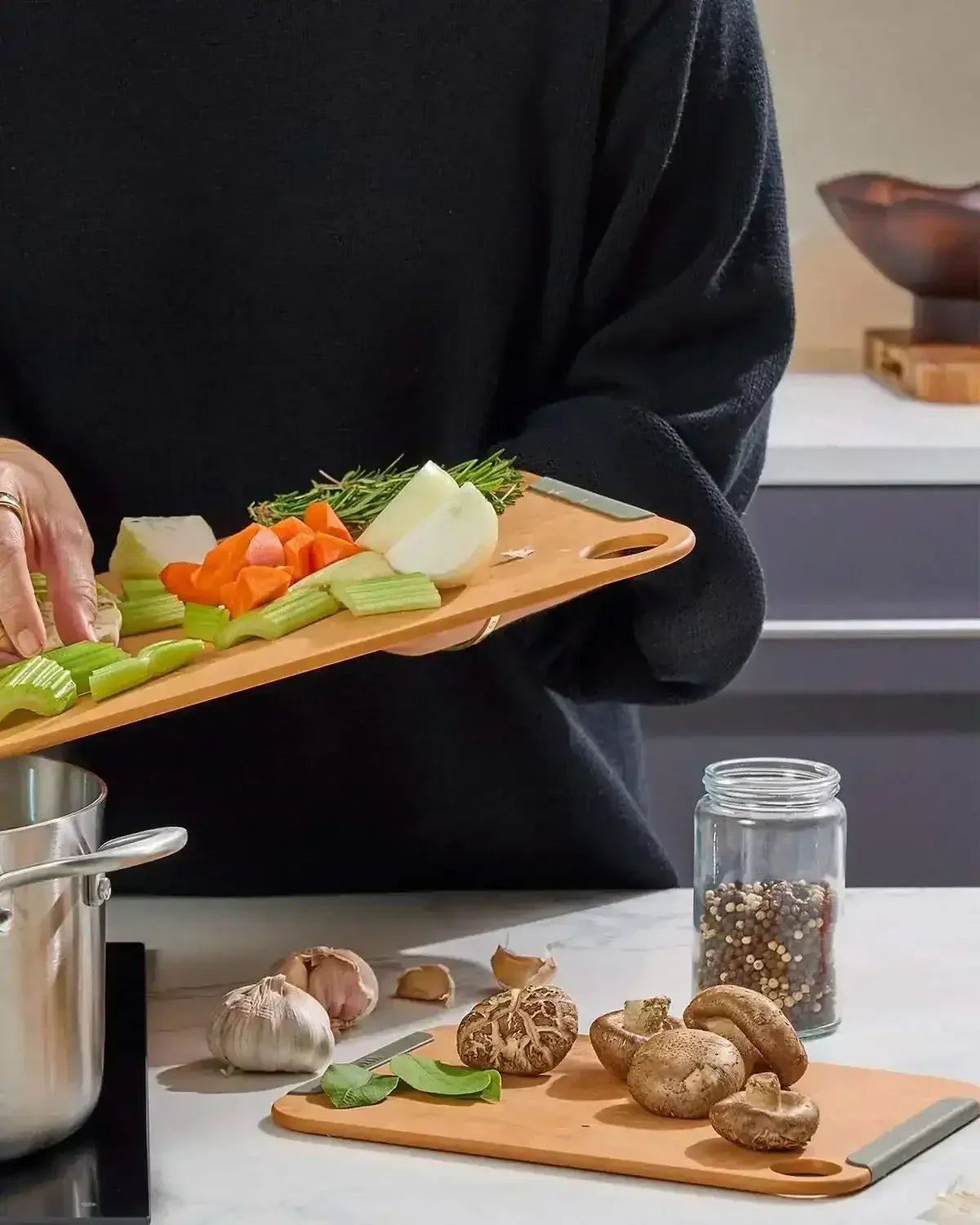 Person using small non-slip wood fibre chopping board for cutting vegetables in a kitchen