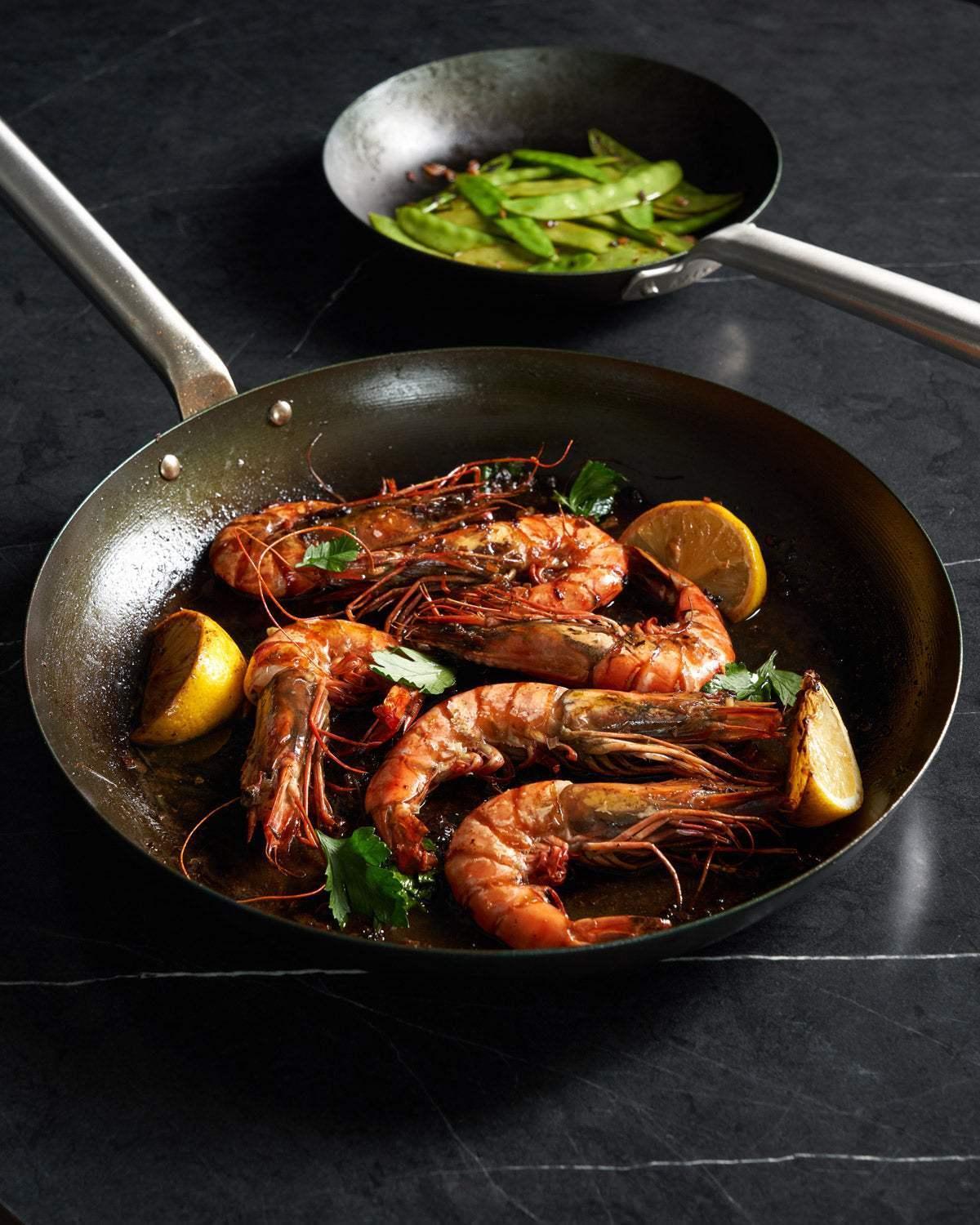 MAKO Black Steel 20cm & 31cm Frying Pan Duo - CookDineHost Prawns served in pan snowpeas in background