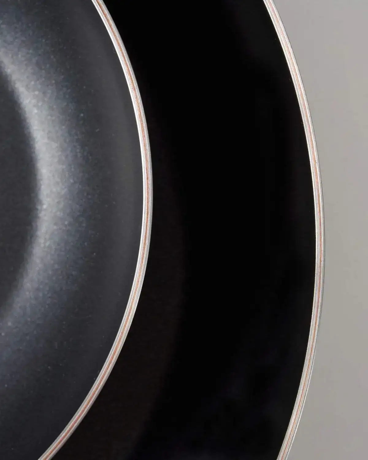 Close-up of Mako non-stick frying pans showing 5-ply layered design and smooth black cooking surface