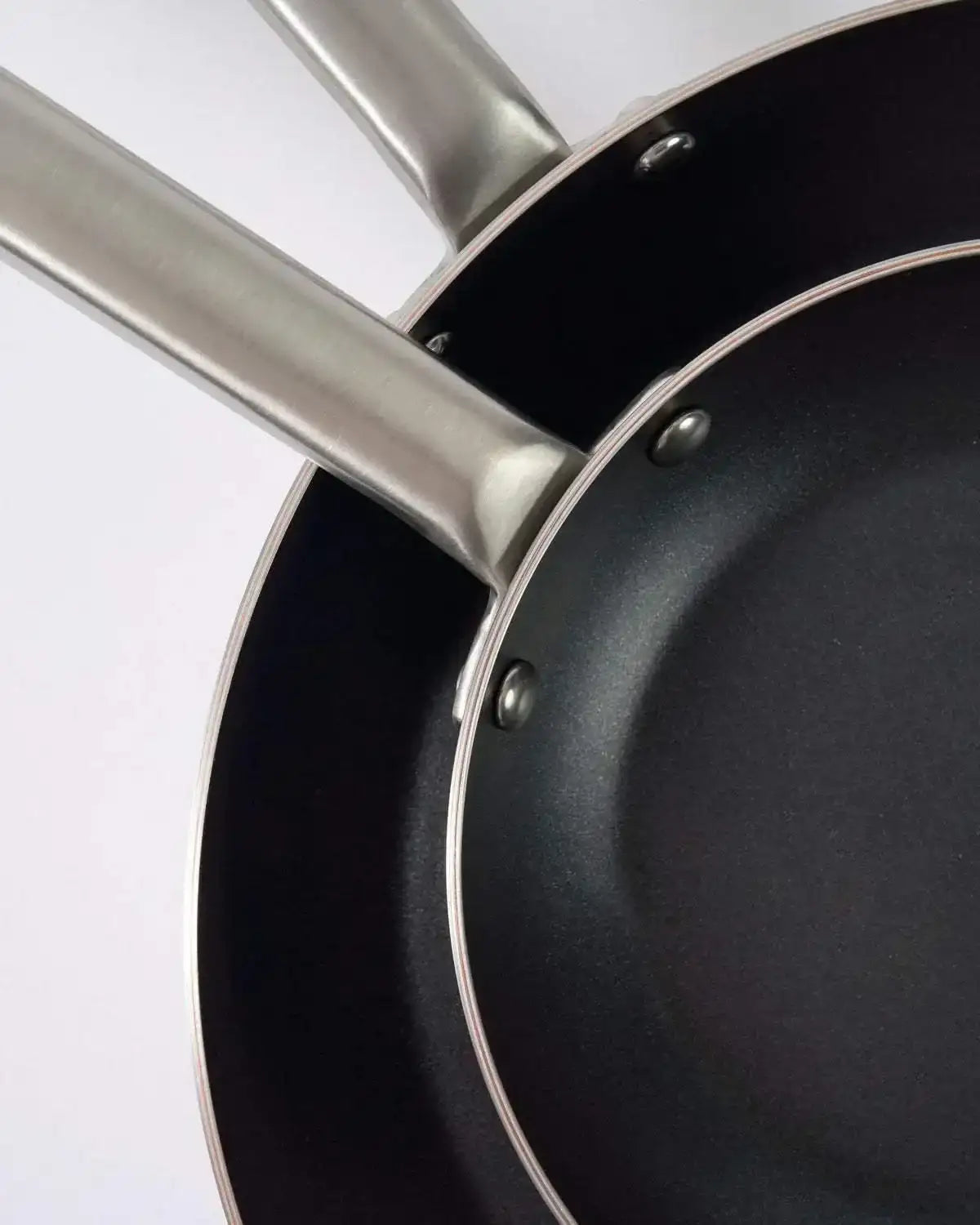 Close-up of two Mako non-stick frying pans with stainless steel handles, 20cm and 30cm, by Marion Grasby