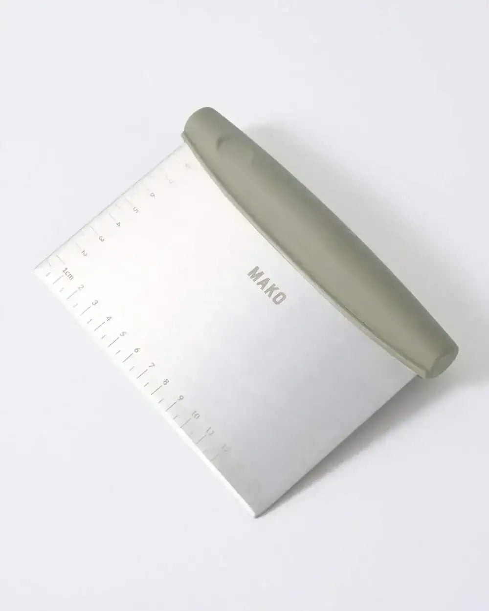 Mako stainless steel dough scraper with gray handle and centimeter ruler, kitchen tool by Marion Grasby