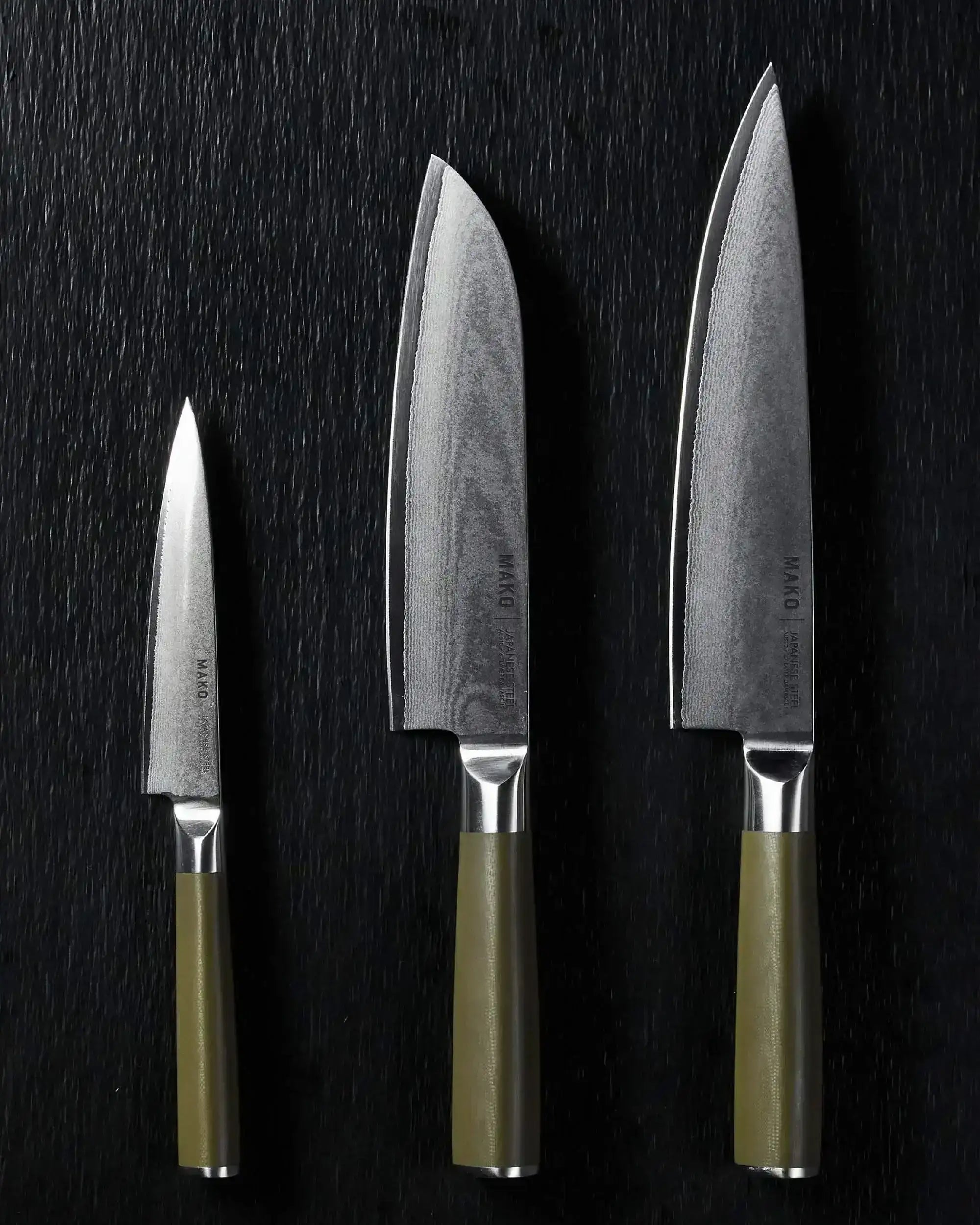 Set of three Mako Japanese steel kitchen knives with olive green handles on black background