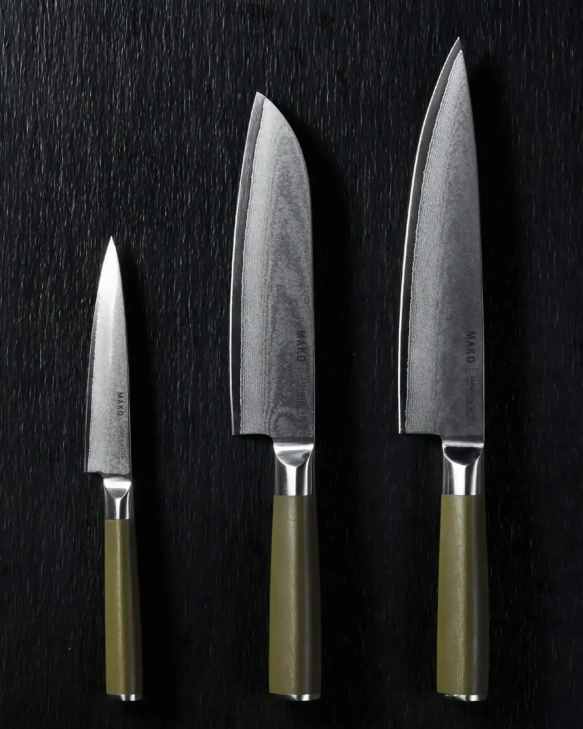 Japanese steel knife set with olive green handles on black background