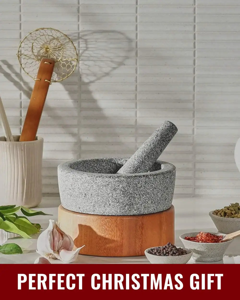 Mako granite mortar and pestle on wooden base with spices and garlic for kitchen cooking