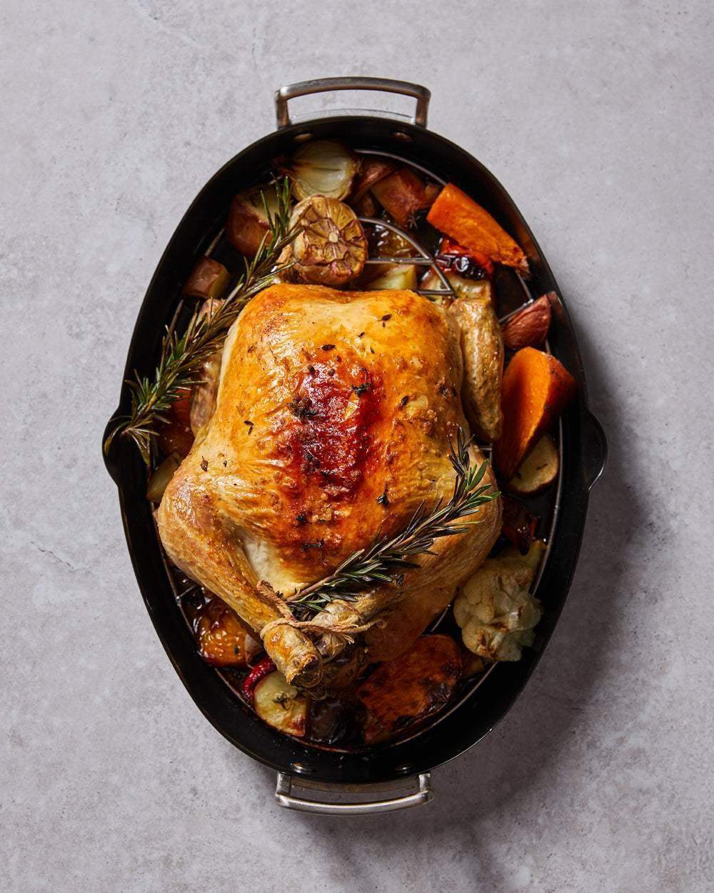 Golden roasted chicken with herbs and vegetables in Marion Grasby's Mako non-stick oval roaster