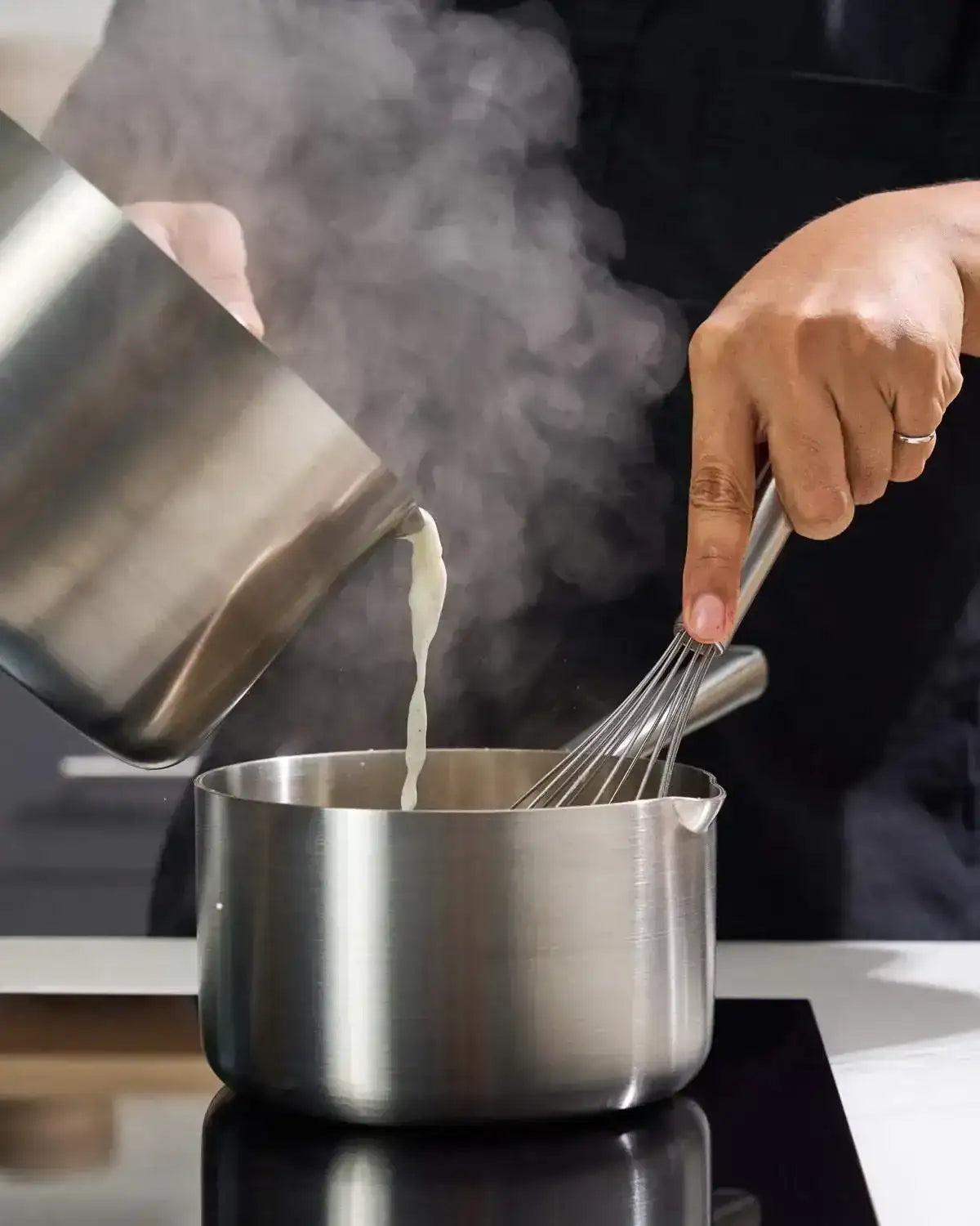 Pouring liquid into MAKO 16cm saucepan on stovetop, stainless steel, CookDineHost Marion Grasby