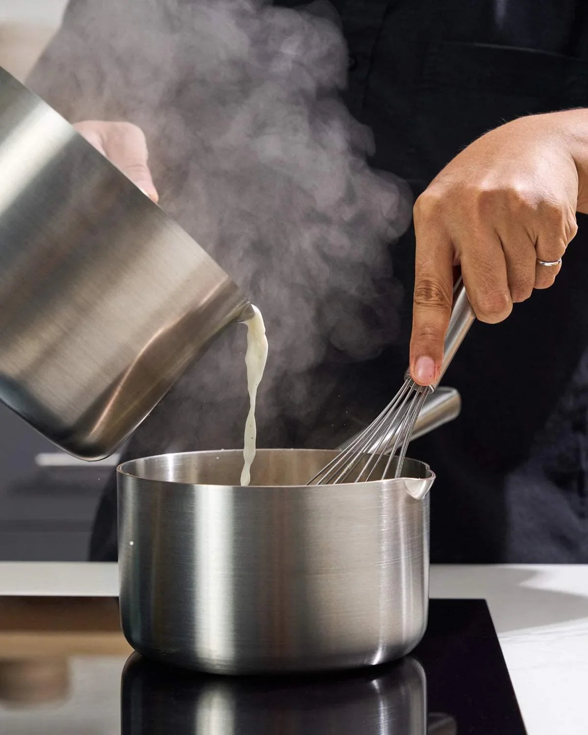 Marion Grasby using Mako Genius 5-ply stainless steel saucepan and whisk on stovetop with steam