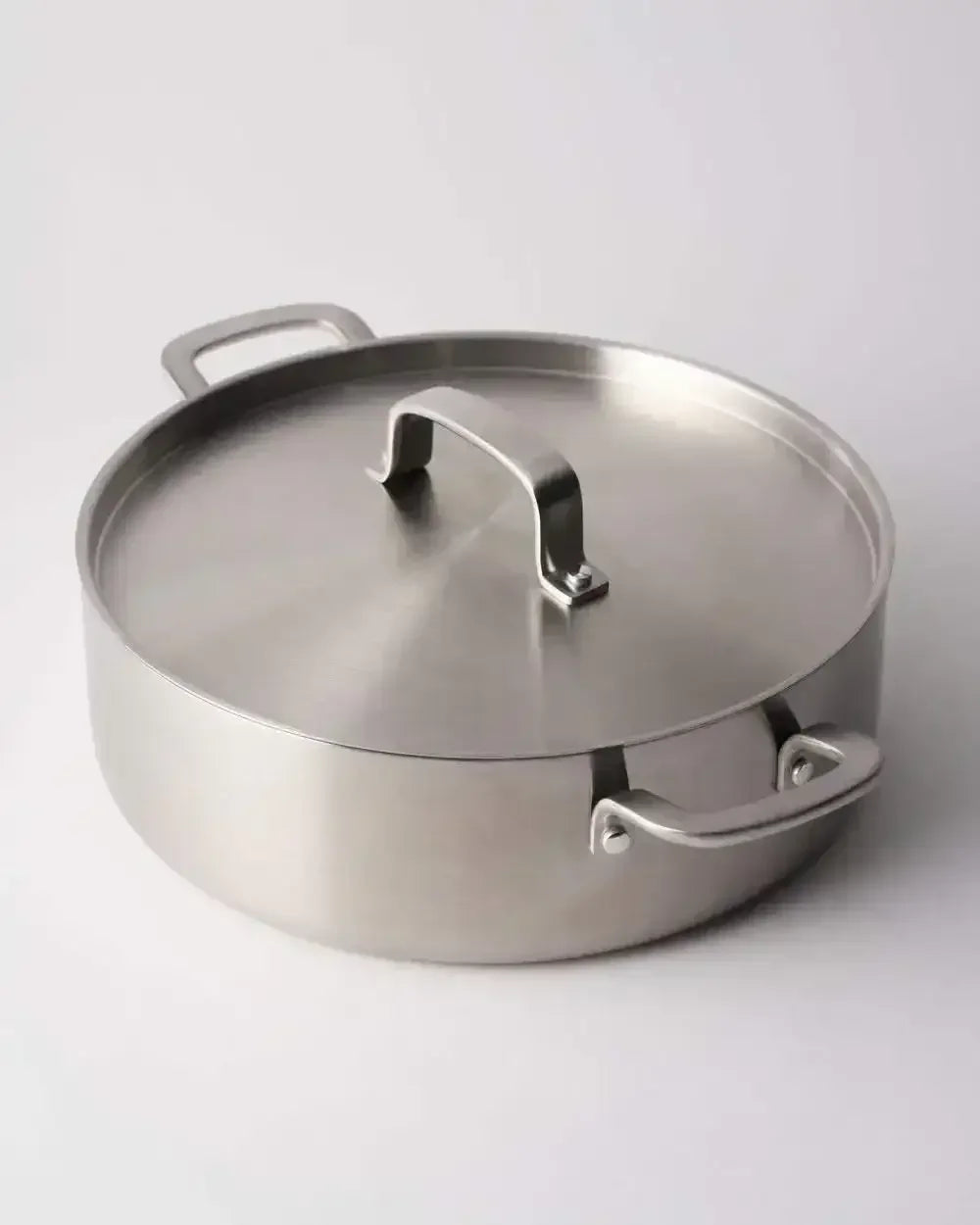 Stainless steel saucepan with lid and handles on a white background, modern cookware