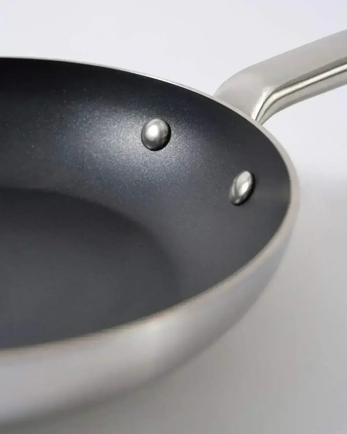 Close-up of nonstick stainless steel saucepan with ergonomic handle on white background