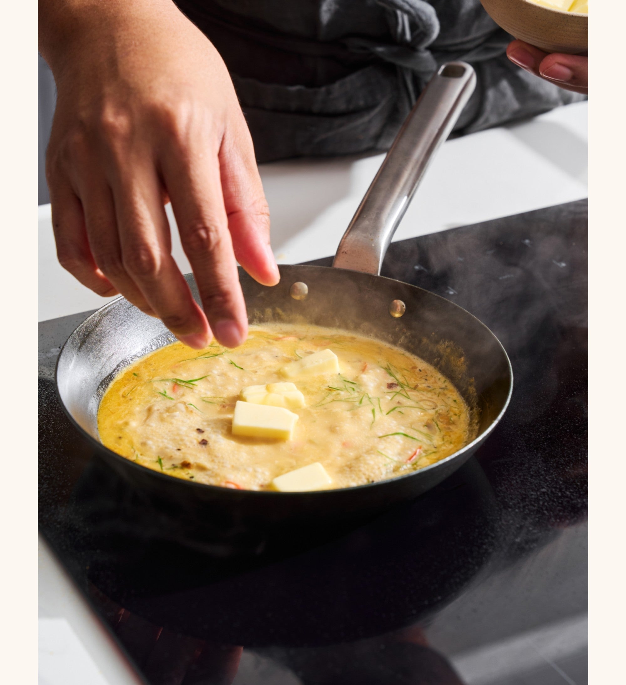 Adding butter to MAKO frying pan on a stove