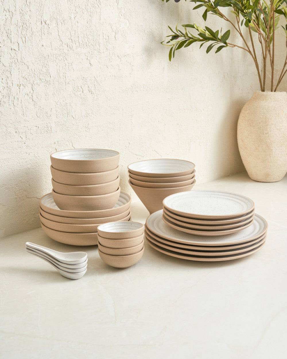 28-piece ceramic dinnerware set with white speckle plates, bowls, and serving spoons on table