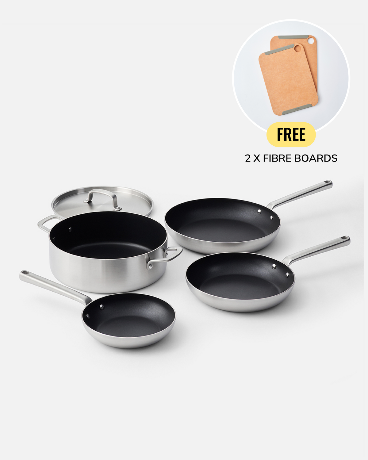 A set of stainless steel cookware including a saucepan with lid, two frying pans, and two skillets, arranged on a light gray background. A circular inset in the top right shows two cork fibre boards with the text 'FREE 2 X FIBRE BOARDS'.