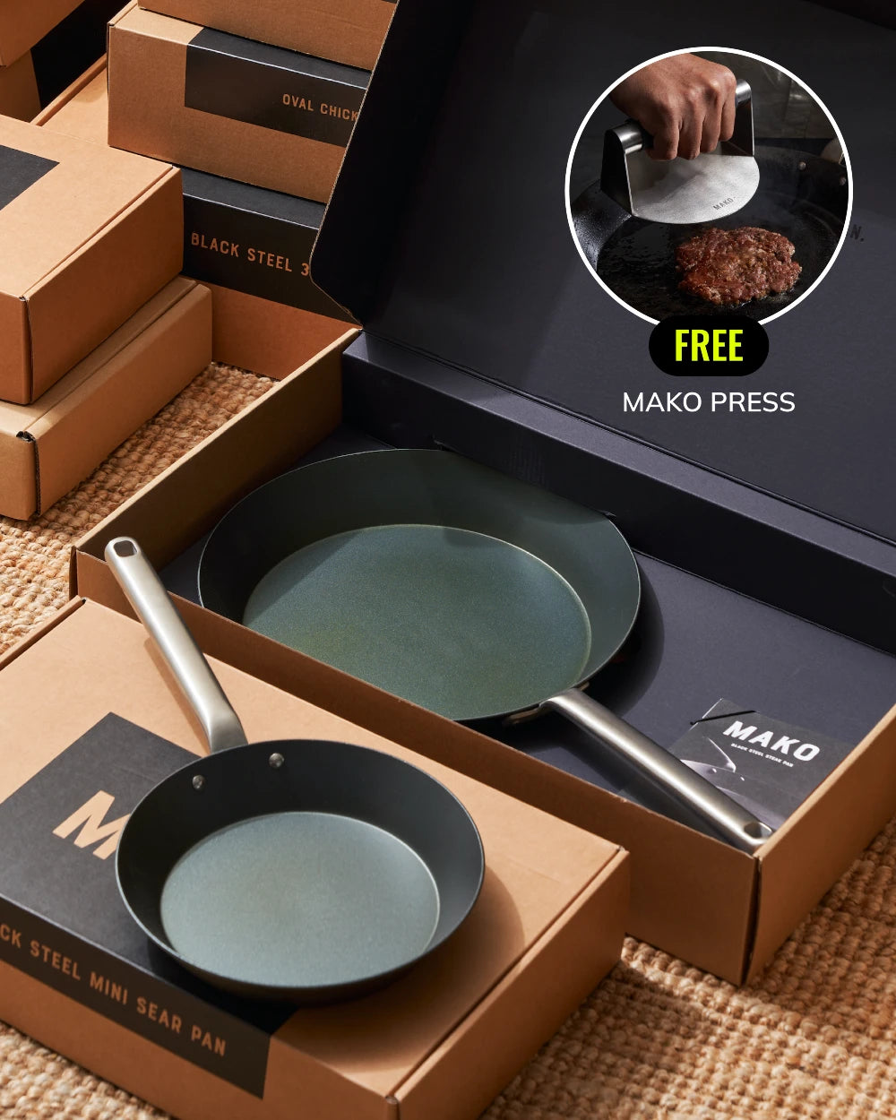 MAKO Black Steel Steak & Mini Sear Pan Set with a Free Press CookDineHost in boxes diagonal angle on grass mat