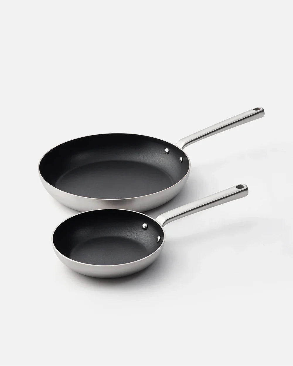 Set of two nonstick frying pans with stainless steel handles on a white background