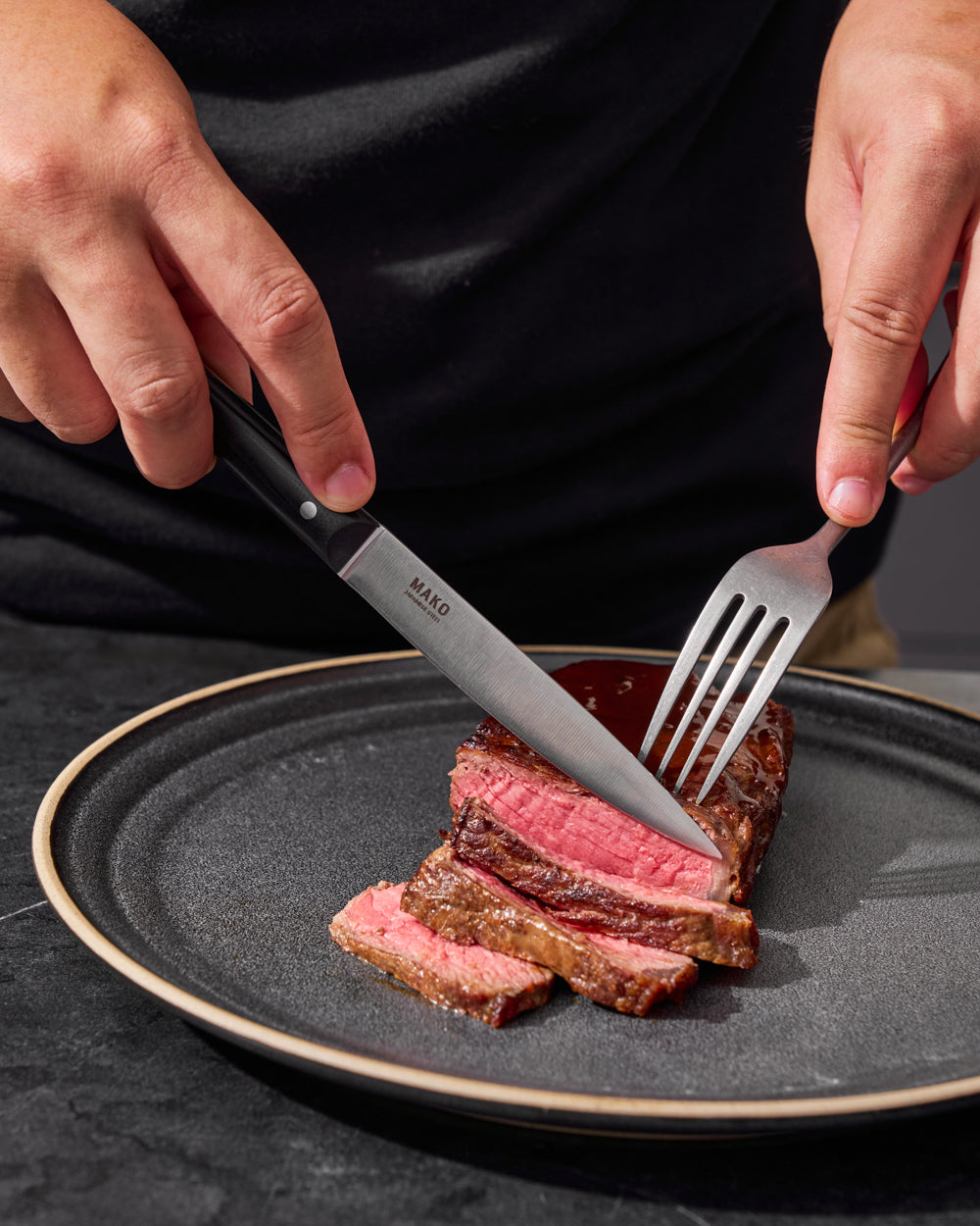 MAKO Steak Knife Set of 6 - Black in use cutting steak on Charcoal Anaya plate with fork