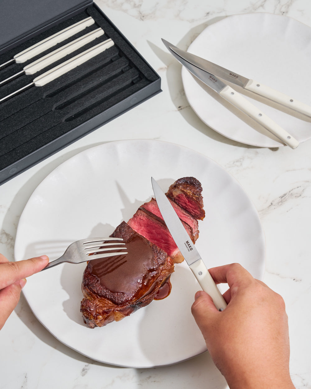 MAKO Steak Knife Set of 6 - Cream in use cutting steak on Calida plate with box in background. Gravy