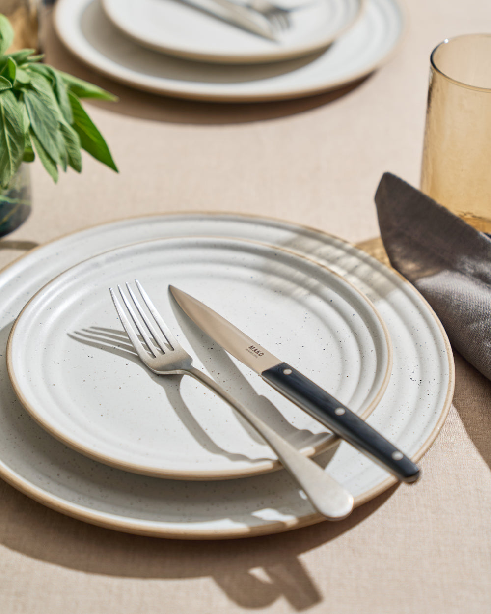 MAKO Steak Knife Set of 6 - Black with for on Anaya plates table setting with sage  in background grey napkin and glass
