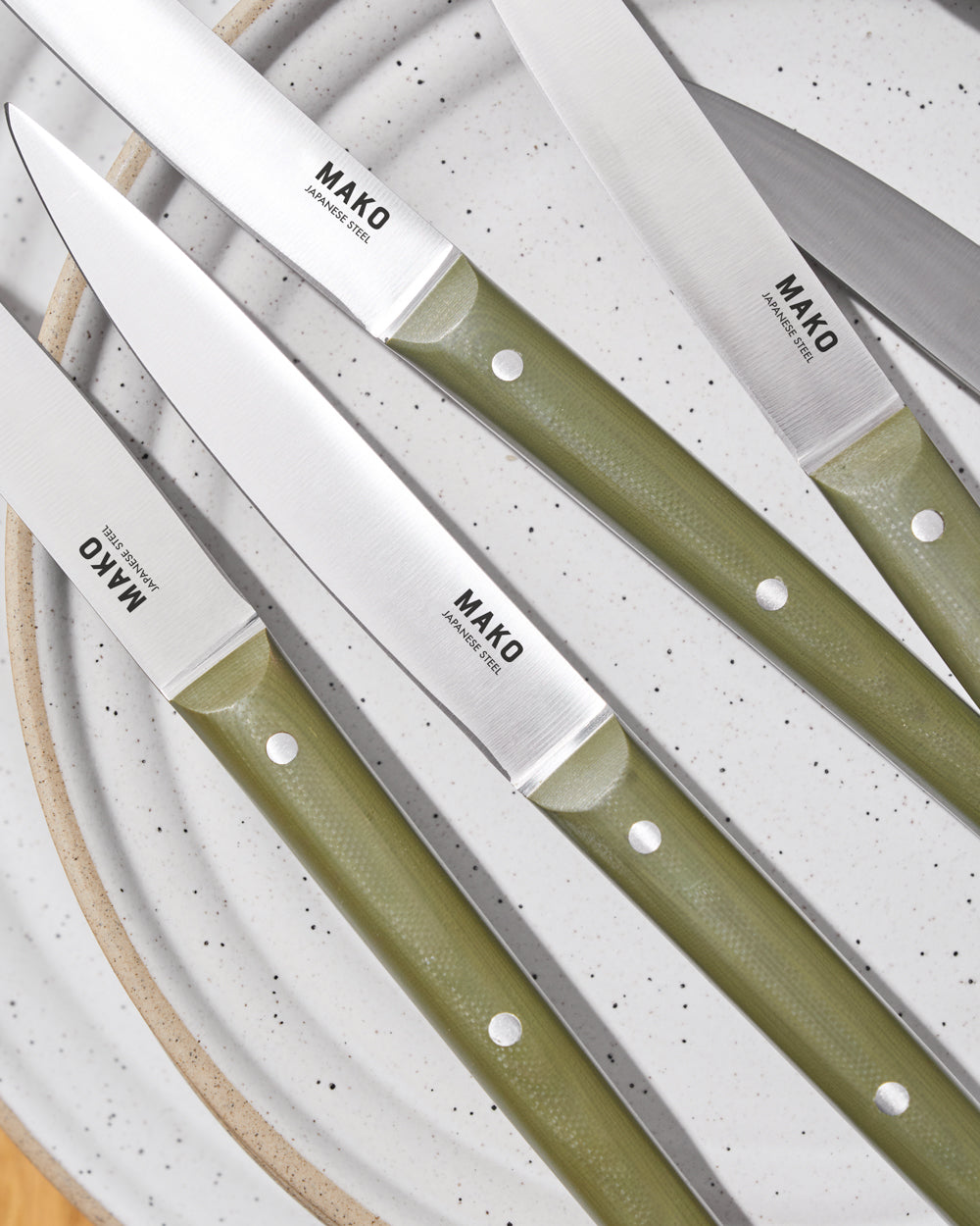 MAKO Steak Knife Set of 6 - Olive Green on a plate up close with handle and blade detail