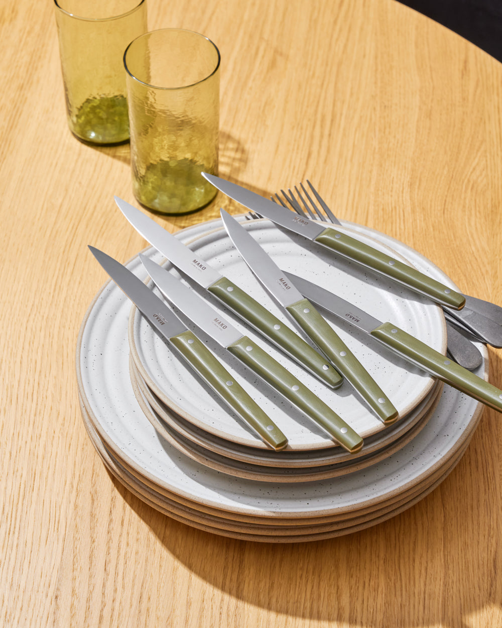 MAKO Steak Knife Set of 6 - Olive Green n stack of plates on a table lifestyle