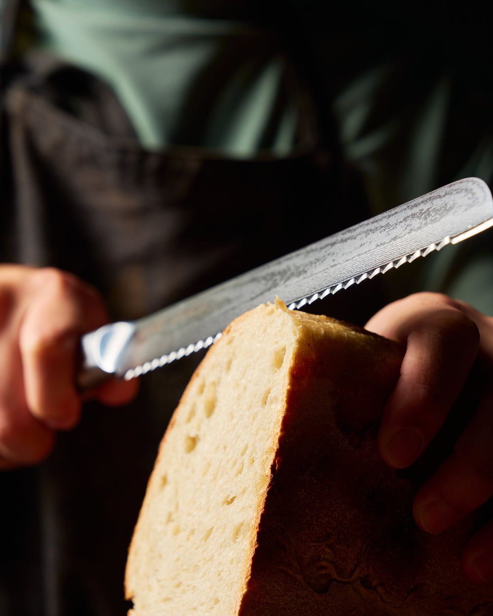 MAKO Japanese Steel Cream 8″ Bread Knife CookDineHost slicing through bread close up blade detail