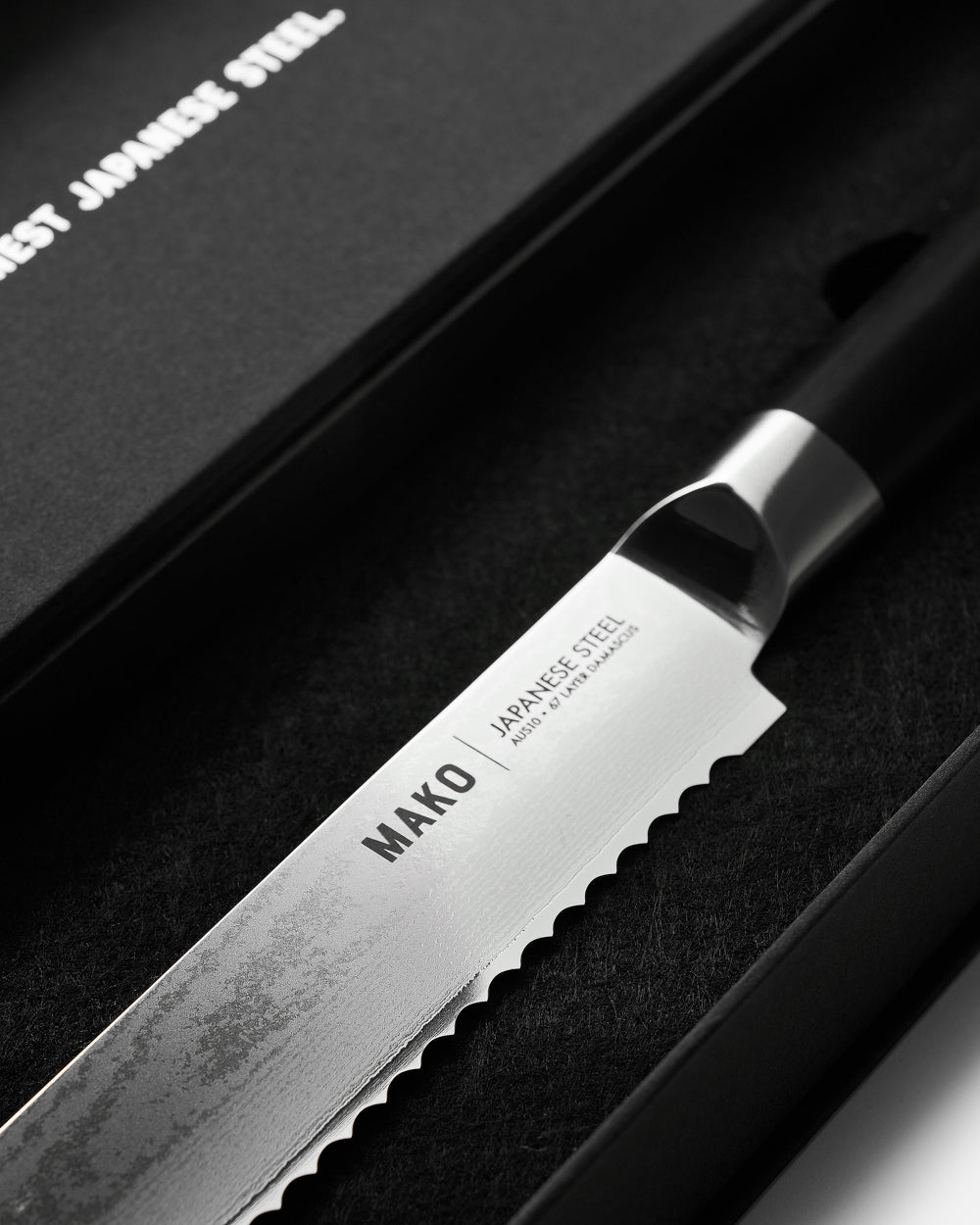 MAKO Japanese Steel Black 8″ Bread Knife close up shot to branding and blade in black box CookDineHost