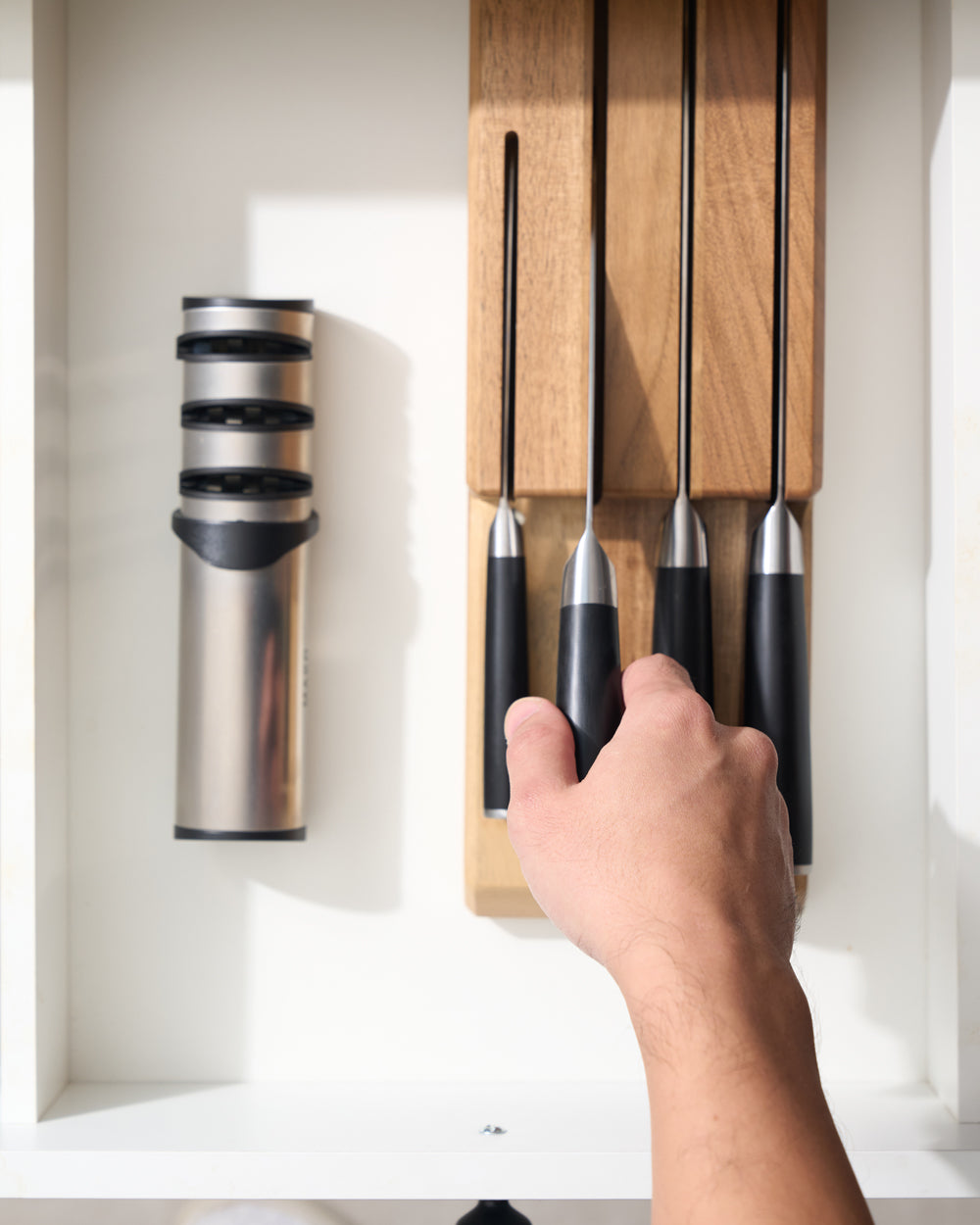 MAKO Japanese Steel Knife Set of 4 - Black  lifting the Santoku knife out of the storage in the drawer