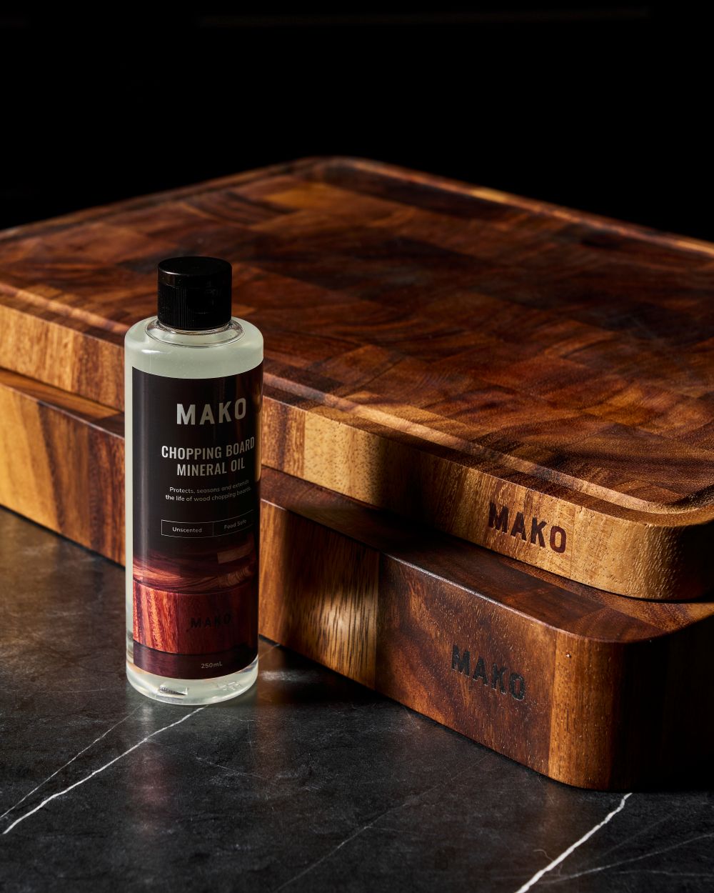 MAKO Chopping Board Mineral Oil next to MAKO Master Board and Butchers Block on black marble
