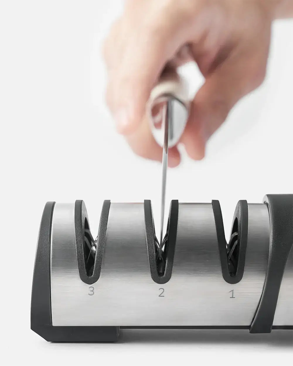 Hand sharpening knife blade on stainless steel Mako knife sharpener with three-stage slots