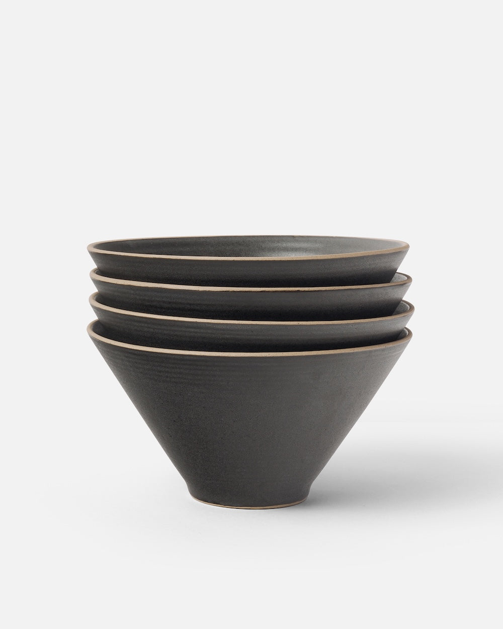 Stacked set of four matte charcoal ceramic noodle bowls on white background