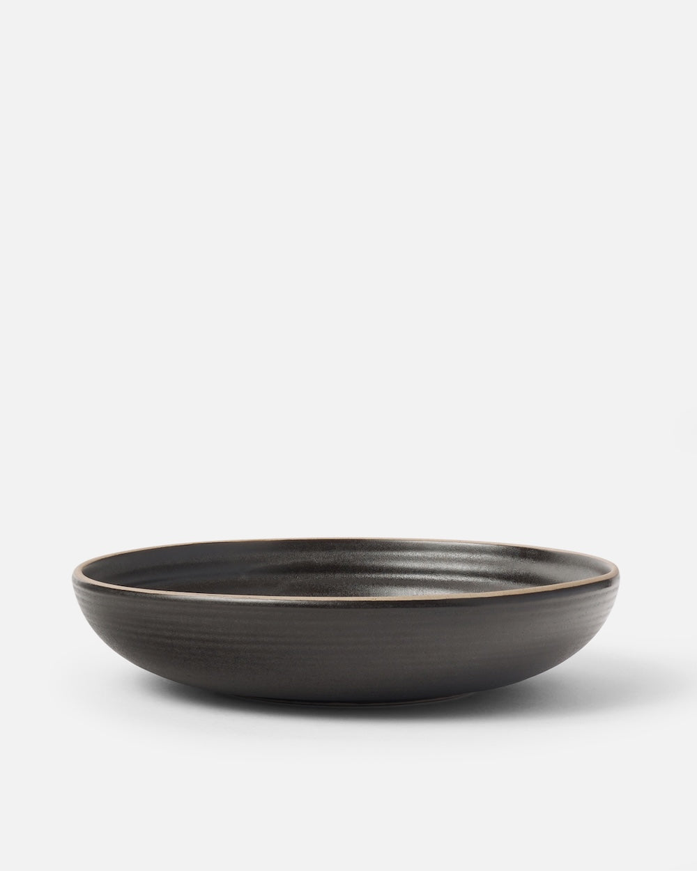 Charcoal ceramic wide bowl with matte finish on a plain background, modern tableware.