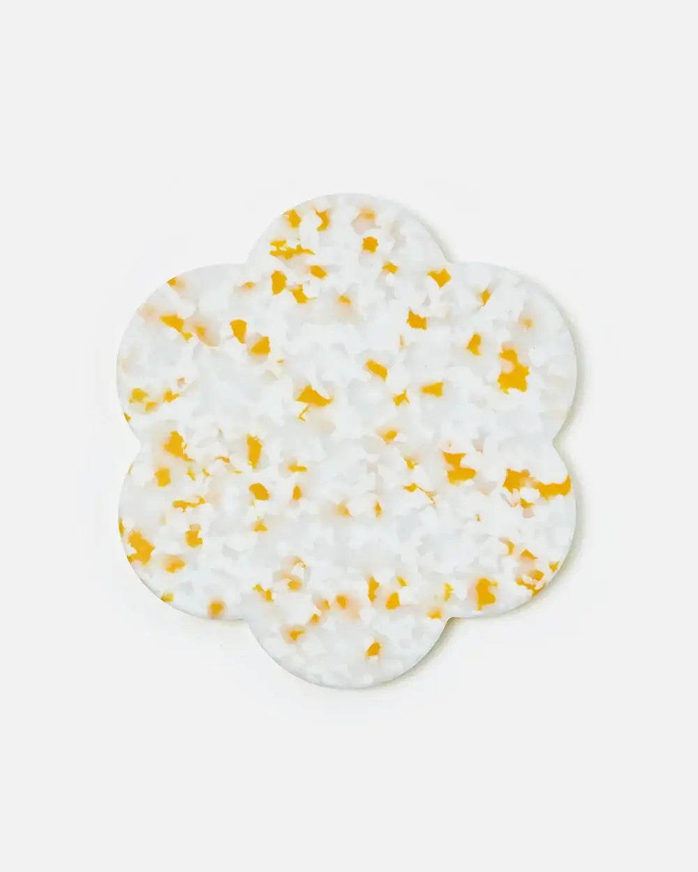 Scalloped white decorative coaster with yellow terrazzo pattern on a plain background.