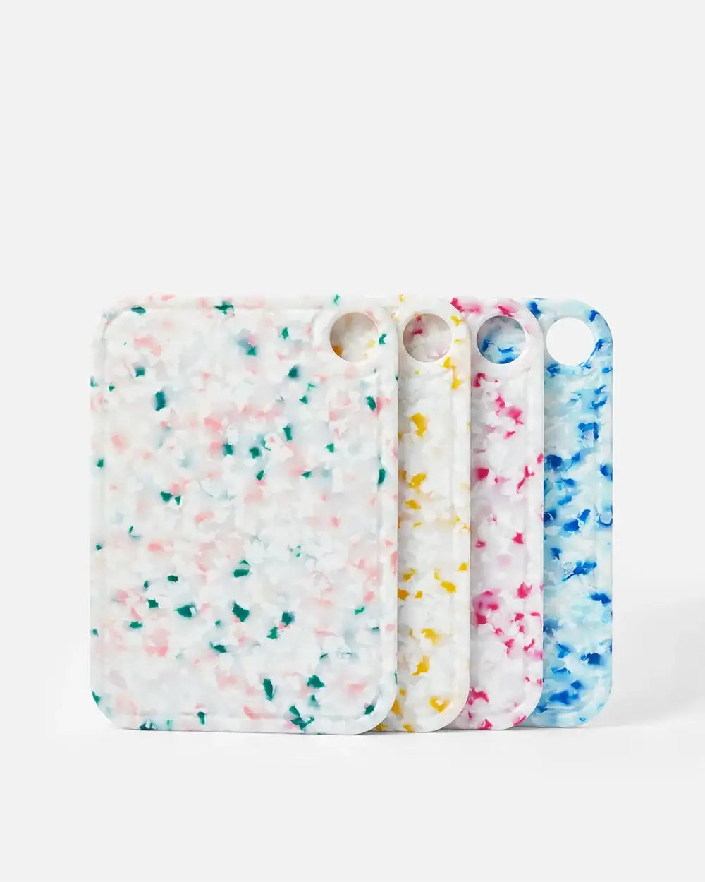 Set of four colorful terrazzo-style cutting boards with round hanging holes, kitchen accessories