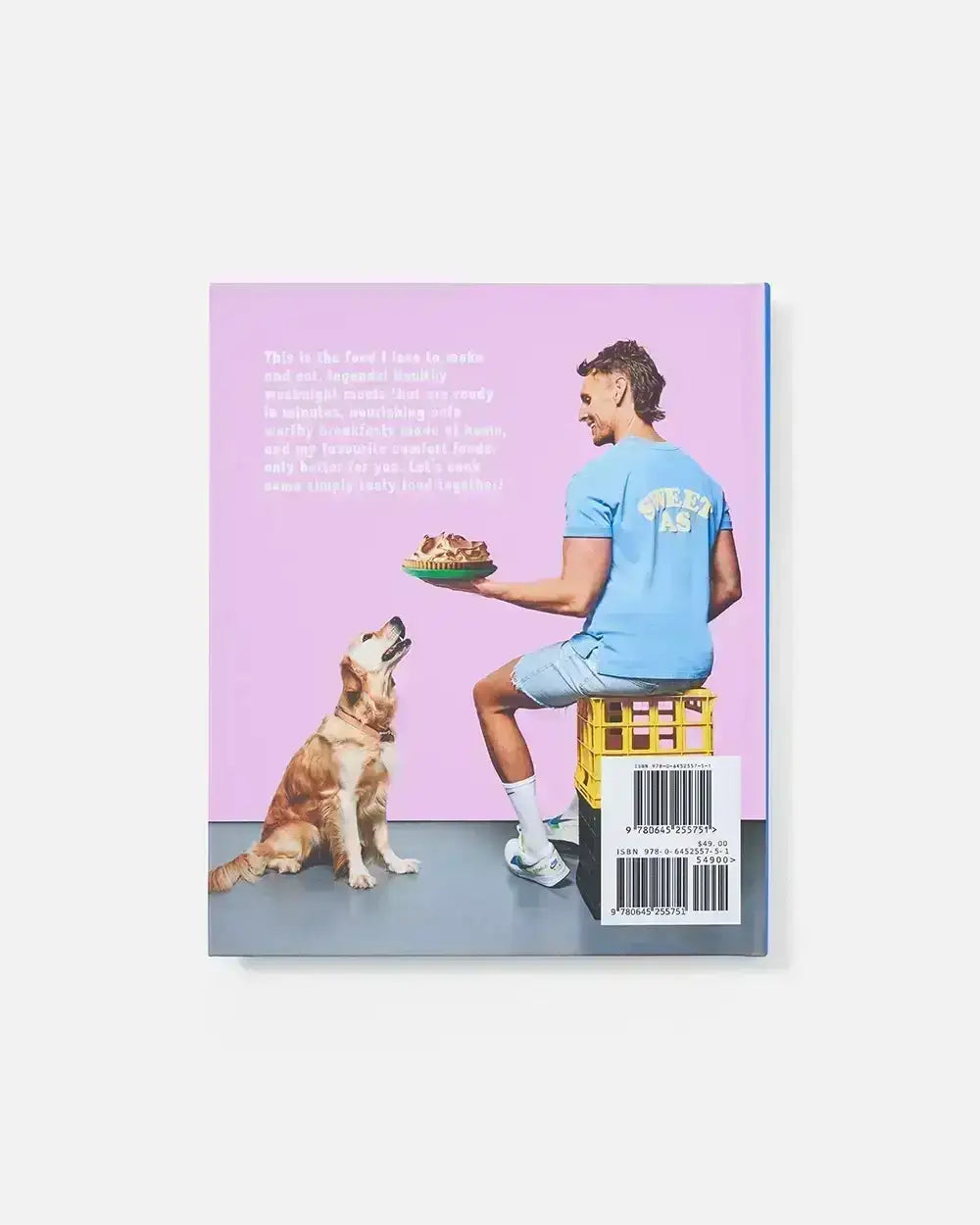 Cookbook back cover showing man in blue shirt holding pie, seated on crate, with golden retriever looking up