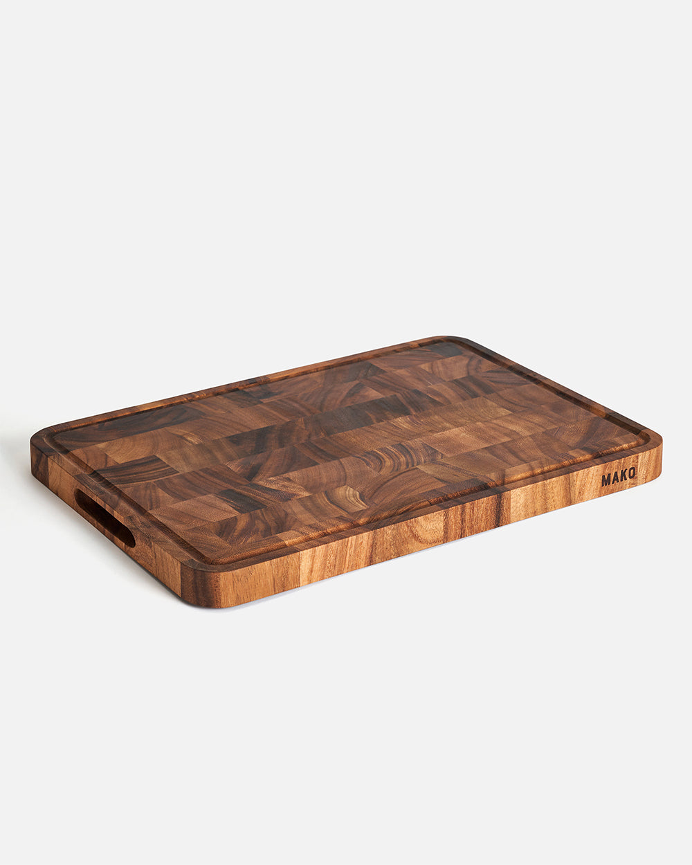Rectangular wooden chopping board with juice groove and handle slots on white background