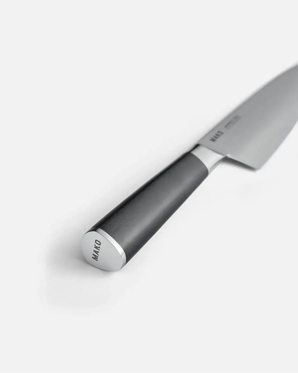Close-up of Mako chef knife with black ergonomic handle and stainless steel blade on white background
