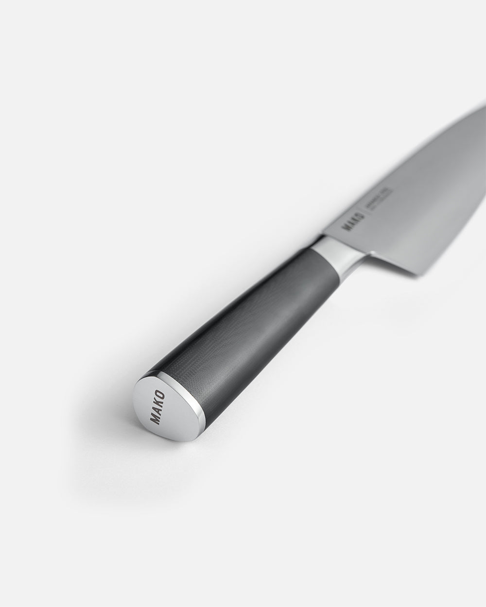 Close-up of MAKO chef knife with sleek black handle on white background