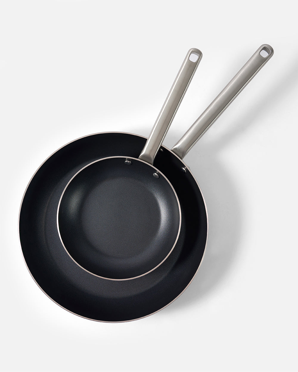 Two black non-stick frying pans with stainless steel handles on a white background