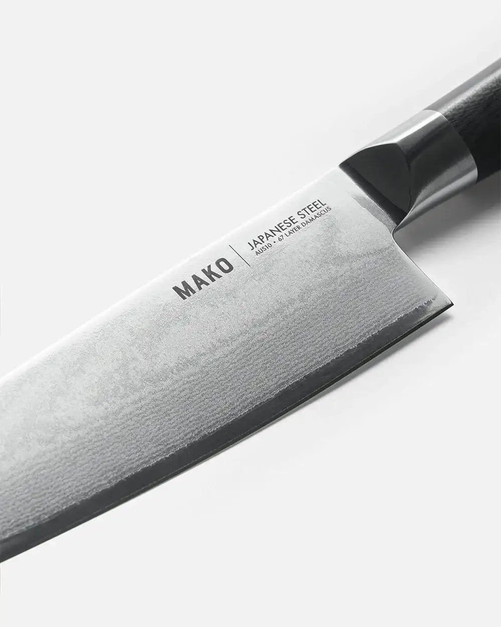 Close-up of MAKO Japanese steel Santoku knife blade with black handle by Marion Grasby