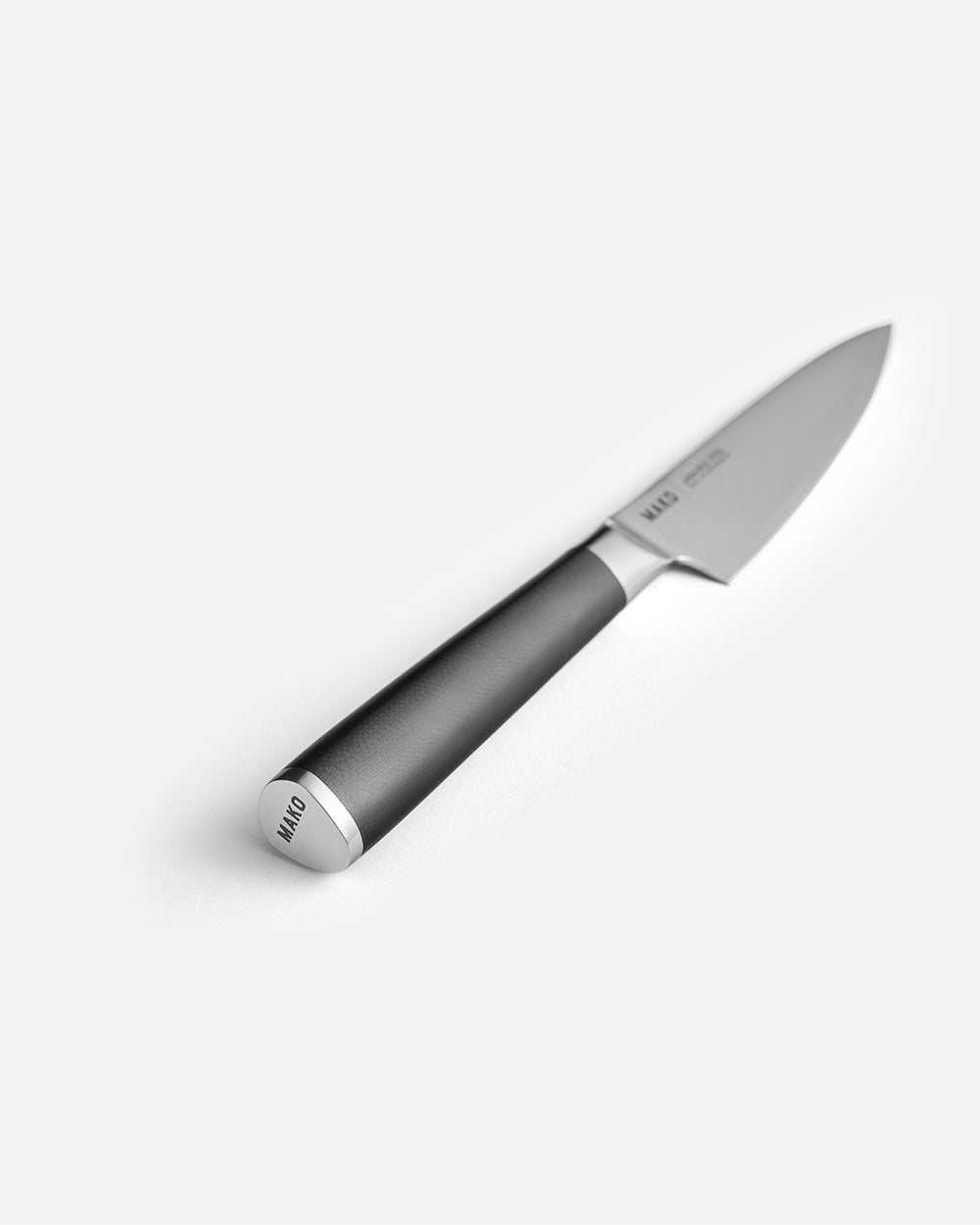 Stainless steel utility kitchen knife with a black handle on a plain white background